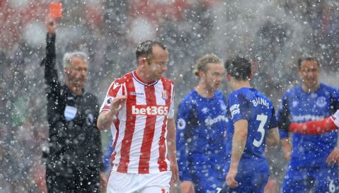 Stoke City's Charlie Adam is shown the red card by referee Martin Atkinson during the English Premier League soccer match between Stoke City and Everton, at the bet365 Stadium, in Stoke, England, Saturday March 17, 2018. (Mike Egerton/PA via AP)