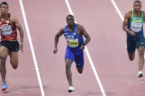 Christian Coleman of the U.S., center, runs to finish below 10 seconds during the men's 100 meters heats during the World Athletics Championships Friday, Sept. 27, 2019, in Doha, Qatar. Left is Japan's Abdul Hakim Sani Brown, right is Brazil Rodrigo Do Nascimento. (AP Photo/Martin Meissner)
