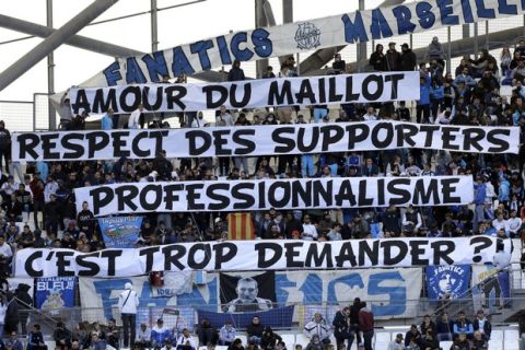 Marseille supporters display banners reading "Love of the jersey, respect for supporters, professionalism, is it too much to ask?", prior to the League One soccer match between Marseille and Caen, at the Velodrome stadium, in Marseille, southern France, Sunday, Nov. 5, 2017. Supporters react after Marseille's player Patrice Evra kicked the head of a supporter of Marseille before the Europa League match against Vitoria SC Guimaraes. (AP Photo/Claude Paris)