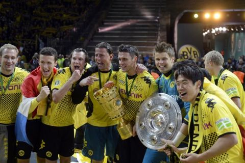 Dortmund's players celebrate with the trophies of the German Cup (C) and the Bundesliga first division (R) after their team won the German cup " DFB Pokal " final football match Borussia Dortmund vs Bayern Munich at the Olympiastadion in Berlin on May 12, 2012. Dortmund defeated Munich 5-2.     AFP PHOTO / ODD ANDERSEN


RESTRICTIONS / EMBARGO - DFB LIMITS THE USE OF IMAGES ON THE INTERNET TO 15 PICTURES (NO VIDEO-LIKE SEQUENCES) DURING THE MATCH AND PROHIBITS MOBILE (MMS) USE DURING AND FOR FURTHER TWO HOURS AFTER THE MATCH. FOR MORE INFORMATION CONTACT DFB.ODD ANDERSEN/AFP/GettyImages