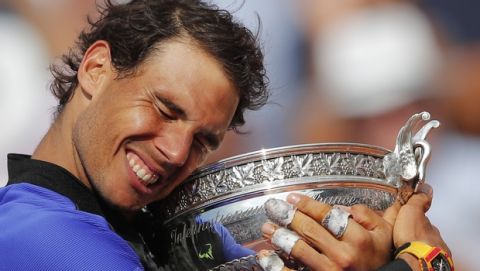 FILE - In this June 11, 2017, file photo, Spain's Rafael Nadal holds the trophy as he celebrates winning his tenth French Open title, against Switzerland's Stan Wawrinka, at Roland Garros stadium, in Paris, France. Federer leads the list with 20 Grand Slam singles titles. Nadal has 19. Novak Djokovic has 16. (AP Photo/Christophe Ena, File)