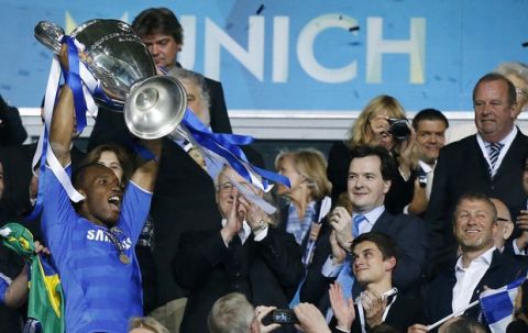 Chelsea's Didier Drogba,left, holds up the trophy after they beat Bayern Munich in the Champions League final soccer match in Munich, Germany Saturday May 19, 2012. Drogba scored the game-winning penalty kick in the shootout. At right is Chelsea owner Roman Abramovich. (AP Photo/Matt Dunham)