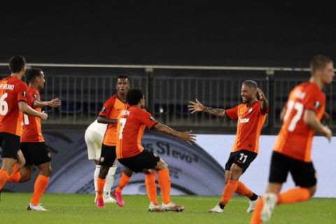 Shakhtar's Taison, center, celebrates with teammates after scoring his side's second goal during the Europa League quarter-final soccer match between Shakhtar Donetsk and FC Basel at the Veltins-Arena in Gelsenkirchen, Germany, Tuesday, Aug. 11, 2020. (Lars Baron/Pool via AP)