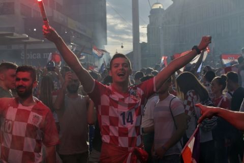 A supporter of the Croatian national soccer team lights a flare in central Zagreb, Croatia, Sunday, July 15, 2018. Croatia's national soccer team lost to France in the World Cup final in Russia. (AP Photo/Marko Drobnjakovic)