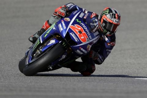 Maverick Vinales (25), of Spain, steers through a turn during a warm up session for the Grand Prix of the Americas MotoGP motorcycle race, Sunday, April 23, 2017, in Austin, Texas. (AP Photo/Eric Gay)