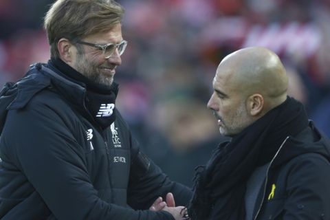 Liverpool's manager Juergen Klopp, left, shakes hands with Manchester City's manager Pep Guardiola prior to the English Premier League soccer match between Liverpool and Manchester City at Anfield Stadium, in Liverpool, England, Sunday Jan. 14, 2018. (AP Photo/Dave Thompson)