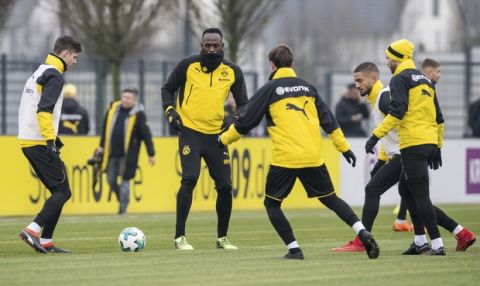 Jamaica's former sprinter Usain Bolt, center, takes part in a practice session of the Borussia Dortmund soccer squad in Dortmund, Germany, Friday, March 23, 2018. From left Dortmund's Julian Weigl, Mario Goetze,  Jeremy Toljan and Gonzalo Castro  attend the training. (Guido Kirchner/dpa via AP)
