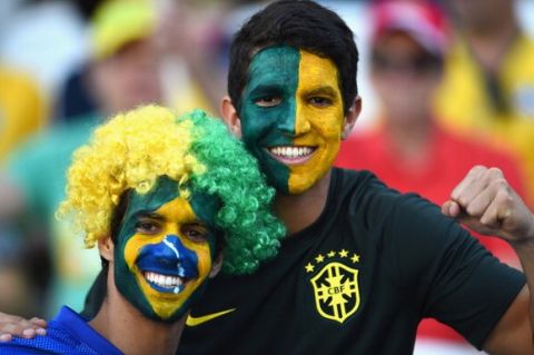 SAO PAULO, BRAZIL - JUNE 12: Brazil fans with painted faces smile before the 2014 FIFA World Cup Brazil Group A match between Brazil and Croatia at Arena de Sao Paulo on June 12, 2014 in Sao Paulo, Brazil.  (Photo by Buda Mendes/Getty Images)