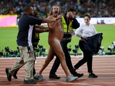 A streaker is apprehended by security after he ran onto the track during the World Athletics Championships in London, Saturday, Aug. 5, 2017. (AP Photo/Kirsty Wigglesworth)