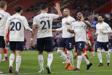 Manchester City's Raheem Sterling, second right, celebrates with teammates after scoring during the English Premier League soccer match between Southampton and Manchester City at the St Mary's Stadium, in Southampton, Saturday, Dec. 19, 2020. (Adrian Dennis/Pool via AP)