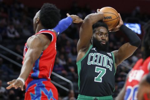 Boston Celtics guard Jaylen Brown (7) passes the ball while being guarded by Detroit Pistons guard Hamidou Diallo, left, during the first half of an NBA basketball game Saturday, Feb. 26, 2022, in Detroit. (AP Photo/Duane Burleson)