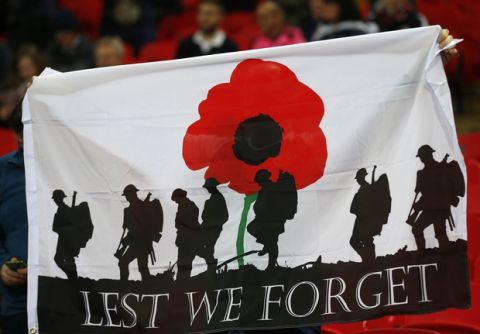 A banner showing the silhouette of troops and a large red poppy with the words 'Lest We Forget' is held up by a fan prior to the start of the World Cup 2018 Group F qualification soccer match between England and Scotland at Wembley stadium in London, Friday, Nov. 11, 2016. The game take place on Armistice Day, Nov. 11, when poppies are traditional worn in memory of those who gave their lives in the service of their country in past and present conflicts. (AP Photo/Frank Augstein)