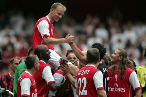 Arsenal's Dennis Bergkamp is carried by players from Arsenal and Ajax at the end of his last game at Arsenal at the Emirates stadium, London, Saturday July 22,  2006.  Saturday's match, the first game to be played in Arsenal's new home stadium, is a tribute match between Arsenal and Ajax to mark the retirement of star striker Dennis Bergkamp.(AP Photo/Tom Hevezi)