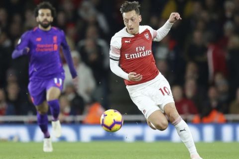 Arsenal's Mesut Ozil runs with the ball during the English Premier League soccer match between Arsenal and Liverpool at Emirates stadium in London, England, Saturday, Nov. 3, 2018. (AP Photo/Tim Ireland)