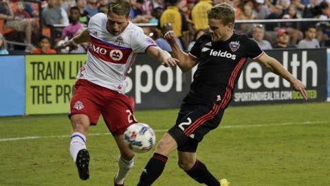 Toronto FC midfielder Nicolas Hasler (26) shoots the ball past D.C. United defender Taylor Kemp (2) during the second half of an MLS soccer match, Saturday, Aug. 5, 2017, at RFK Stadium in Washington. The game ended in a 1-1 draw. (AP Photo/Pablo Martinez Monsivais)