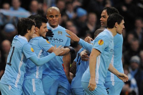 Manchester City's Argentinian forward Sergio Aguero (2-L) celebrates with Manchester City's Belgian midfielder Vincent Kompany (C) after scoring the opening goal during the UEFA Europa League round of 32 second leg football match between Manchester City and FC Porto at the Etihad stadium in Manchester, north-west England on February 22 2012. AFP PHOTO/ANDREW YATES. (Photo credit should read ANDREW YATES/AFP/Getty Images)