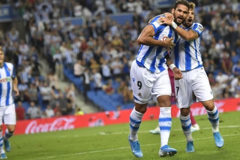 Real Sociedad's Martin Odegaard, back, goes to celebrates with teammates Willian Jose and Portu after Wiilian Jose scored the second goal of their during the Spanish La Liga soccer match between Real Sociedad and Alaves at Reale Arena stadium, in San Sebastian, northern Spain, Thursday, Sept. 26, 2019. (AP Photo/Alvaro Barrientos)
