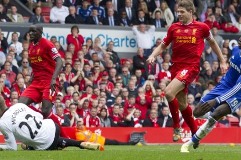 Chelsea's Demba Ba, right, scores past Liverpool goalkeeper Simon Mignolet, below, after an error by captain Steven Gerrard, second right, during their English Premier League soccer match at Anfield Stadium, Liverpool, England, Sunday April 27, 2014. (AP Photo/Jon Super)    