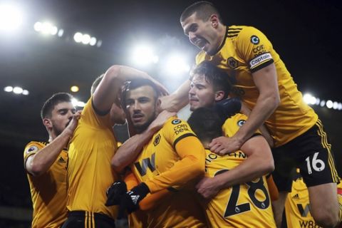 Wolverhampton Wanderers' Romain Saiss, third left, celebrates scoring his side's first goal of the game against West Ham, during their English Premier League soccer match at Molineux in Wolverhampton, England, Tuesday Jan. 29, 2019. (David Davies/PA via AP)