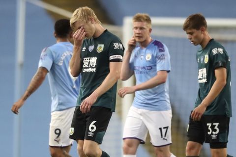 Burnley's Ben Mee reacts as he leaves the field following his team's 5-0 loss during the English Premier League soccer match between Manchester City and Burnley at Etihad Stadium, in Manchester, England, Monday, June 22, 2020. (AP Photo/Martin Rickett,Pool)