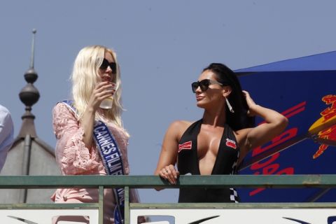 Women stand by the track watch the qualifying for Sunday's Monaco Formula One Grand Prix at the Monaco racetrack, in Monaco, Saturday, May 26, 2018. The Formula one race will be held on Sunday. (AP Photo/Claude Paris)