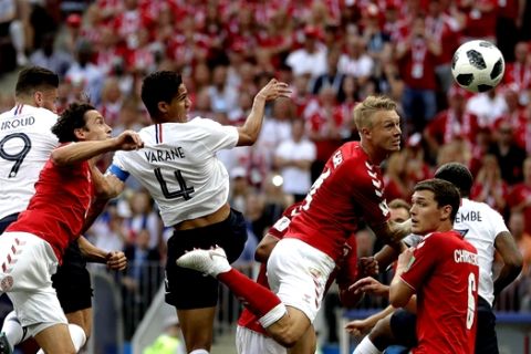 Denmark's Simon Kjaer, top centre right, heads the ball under pressure from France's Raphael Varane top center left, during the group C match between Denmark and France at the 2018 soccer World Cup at the Luzhniki Stadium in Moscow, Russia, Tuesday, June 26, 2018. (AP Photo/Matthias Schrader)