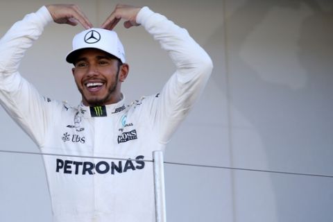Mercedes driver Lewis Hamilton of Britain poses on the podium for his team crew after winning the Japanese Formula One Grand Prix at Suzuka Circuit in Suzuka, central Japan, Sunday, Oct. 8, 2017. (AP Photo/Toru Takahashi)