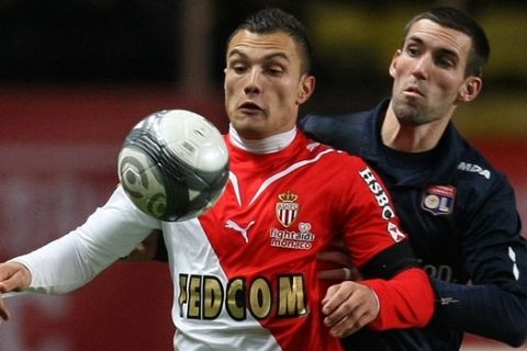 Monaco's Yohan Mollo of France, left, vies for the ball with Lyon's Anthony Reveillere of France, right, during their French League One soccer match, in Monaco stadium, Sunday, Dec. 20, 2009. (AP Photo/Lionel Cironneau)
