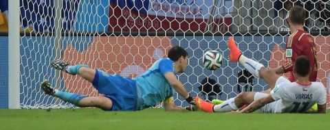 Chile's forward Eduardo Vargas (front) strikes to score Chile's first goal as Spain's goalkeeper and captain Iker Casillas tries to save the ball during a Group B football match between Spain and Chile in the Maracana Stadium in Rio de Janeiro during the 2014 FIFA World Cup on June 18, 2014.  AFP PHOTO / GABRIEL BOUYSGABRIEL BOUYS/AFP/Getty Images