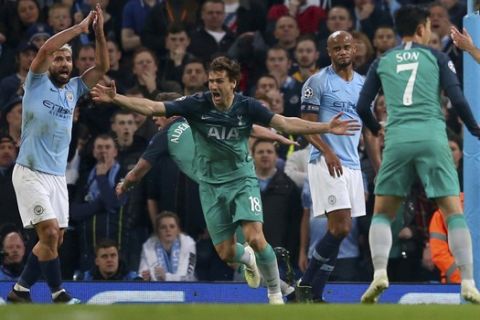 Tottenham's Fernando Llorente, second left, celebrates scoring his side's third goal as Manchester City's Sergio Aguero, left, appeals for handball watched by Manchester City's Vincent Kompany, second right, during the Champions League quarterfinal, second leg, soccer match between Manchester City and Tottenham Hotspur at the Etihad Stadium in Manchester, England, Wednesday, April 17, 2019. (AP Photo/Dave Thompson)