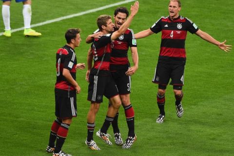 BELO HORIZONTE, BRAZIL - JULY 08:  Thomas Mueller of Germany celebrates scoring his team's first goal with Mats Hummels, Mesut Oezil (L) and Benedikt Hoewedes (R) during the 2014 FIFA World Cup Brazil Semi Final match between Brazil and Germany at Estadio Mineirao on July 8, 2014 in Belo Horizonte, Brazil.  (Photo by Jamie McDonald/Getty Images)