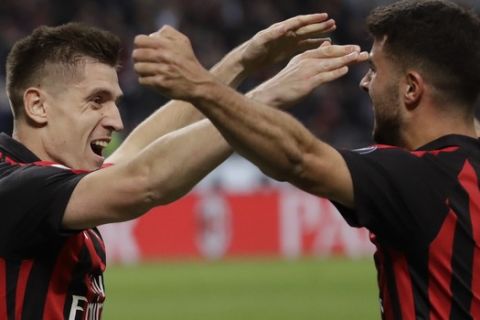 AC Milan's Krzysztof Piatek, left, celebrates with teammate Patrick Cutrone after scoring his side's opening goal during the Serie A soccer match between AC Milan and Udinese, at the San Siro stadium in Milan, Italy, Tuesday, April 2, 2019. (AP Photo/Luca Bruno)