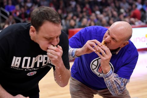Los Angeles Clippers owner Steve Ballmer, right, participates in a hotdog eating contest with cooperative eater Joey Chestnut during the first half of an NBA basketball game between the Clippers and the Houston Rockets, Wednesday, Feb. 28, 2018, in Los Angeles. (AP Photo/Mark J. Terrill)