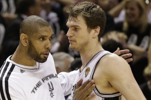 San Antonio Spurs' Tim Duncan celebrates with Tiago Splitter (22), of Brazil, during the second half at Game 3 of the NBA Finals basketball series against the Miami Heat, Tuesday, June 11, 2013, in San Antonio. (AP Photo/Eric Gay) 