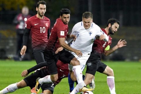 Finland's Robin Lod, second right vies for the ball with Turkey's Hakan Calhanoglu, left, Ismail Koybasi, centre left, Okay Yokuslu, on the ground, and Selcuk Inan right, during the World Cup 2018 Group I  qualification soccer match between Finland and Turkey in Turku, Finland, Monday, Oct. 9, 2017.  (Antti Aimo-Koivisto/Lehtikuva via AP)