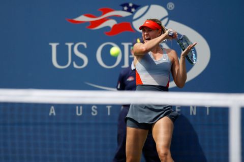 No. 5 seed Maria Sharapova returns a shot to No. 10 Caroline Wozniacki during their fourth-round match in Arthur Ashe Stadium.