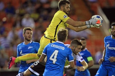 Valencia's Shkodran Mustafi, centre, duels for the ball Zenit's goalkeeper Yuri Lodygin, centre in air, during a Group H Champions League soccer match between Valencia and Zenit Saint Petersburg, at the Mestalla stadium in Valencia, Spain, Wednesday,  Sept. 16, 2015. (AP Photo/Alberto Saiz)