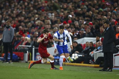 Porto coach Sergio Conceicao , right, and Liverpool coach Jurgen Klopp, left, watch Liverpool's James Milner, enter left, fight for the ball with Porto's Diogo Dalot during the Champions League round of 16, second leg, soccer match between Liverpool and FC Porto at Anfield Stadium, Liverpool, England, Tuesday March 6, 2018. (AP Photo/Dave Thompson)