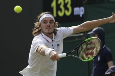 Stefanos Tsitsipas of Greece returns to John Isner of the US during their men's singles match on the seventh day at the Wimbledon Tennis Championships in London, Monday July 9, 2018. (AP Photo/Ben Curtis)