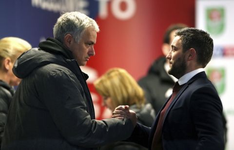 Manchester United manager Jose Mourinho, left, and Bristol City manager Lee Johnson clasp hands prior to the English League Cup Quarter Final soccer match between Bristol City and Manchester United at Ashton Gate, Bristol, England, Wednesday, Dec. 20, 2017. Bristol City defeated Manchester United 2-1. (Nick Potts/PA via AP)