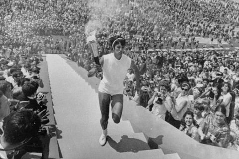 Enriqueta Basilio carries the Olympic torch up the 90 steps to the Olympic flame cauldron during opening ceremonies for the Olympic games in Mexico City October 12, 1968,  Background is part of the vast Olympic stadium.  Enriqueta is the first woman to make the final run of the torch and to light the Olympic flame. (AP Photo)