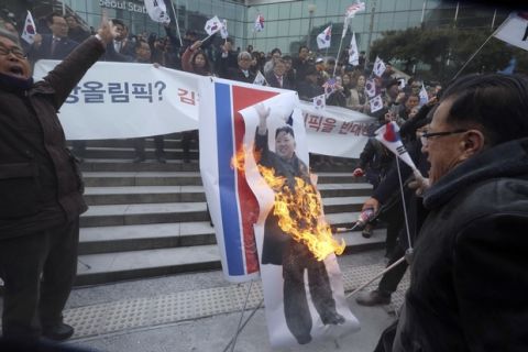 South Korean protesters burn a portrait of North Korean leader Kim Jong Un during a rally against a visit of North Korean Hyon Song Wol, head of a North Korean art troupe, in front of Seoul Railway Station in Seoul, South Korea, Monday, Jan. 22, 2018. Dozens of conservative activists have attempted to burn a large photo of North Korean leader Kim Jong Un as the head of the North's hugely popular girl band passed by them at a Seoul railway station. (AP Photo/Ahn Young-joon)