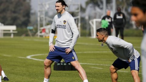 LA Galaxy's newest player Zlatan Ibrahimovic, left, of Sweden, warms up during an MLS soccer training session at the StubHub Center, Friday, March 30, 2018, in Carson, Calif. (AP Photo/Ringo H.W. Chiu)