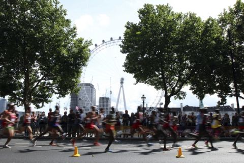 Competitors run past the London Eye as they compete in the Men's Marathon during the World Athletics Championships in London Sunday, Aug. 6, 2017. (AP Photo/Leonore Schick)