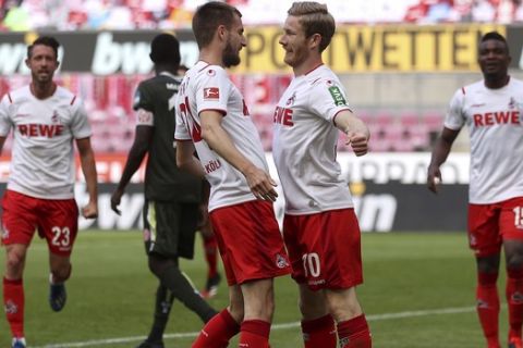 Florian Kainz, right, of 1. FC Koeln celebrates with his teammate Dominick Drexler of 1. FC Koeln after scoring his team's second goal the German Bundesliga soccer match between 1. FC Cologne and FSV Mainz 05 in Cologne, Germany, Sunday, May 17, 2020. The German Bundesliga becomes the world's first major soccer league to resume after a two-month suspension because of the coronavirus pandemic. (AP Photo/Lars Baron, Pool)