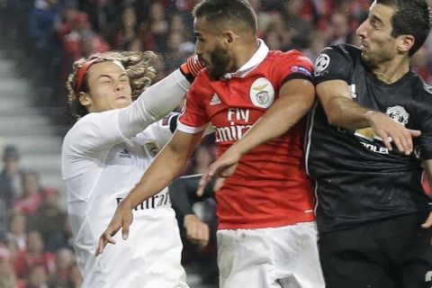 Benfica goalkeeper Mile Svilar, left, and his teammate Douglas, center, jump for the ball with Manchester United's Henrikh Mkhitaryan during their Champions League group A soccer match between Manchester United and Benfica at Benfica's Luz stadium in Lisbon, Wednesday, Oct. 18, 2017. (AP Photo/Armando Franca)