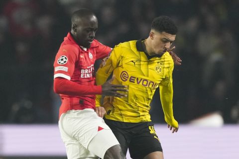 Dortmund's Jadon Sancncho, right, fights for the ball with PSV's Jordan Teze during the Champions League round of 16 first leg soccer match between PSV Eindhoven and Borussia Dortmund at Philips stadium in Eindhoven, Netherlands, Tuesday, Feb. 20, 2024. (AP Photo/Peter Dejong)