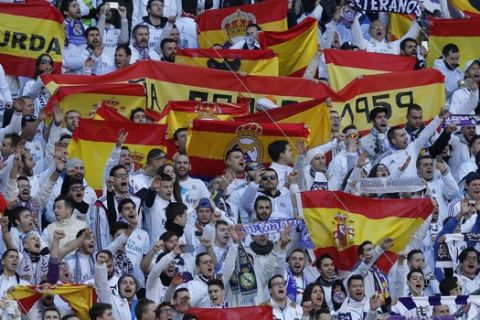 Real Madrid fans hold up Spanish national flags before the start of the Spanish La Liga soccer match between Real Madrid and Barcelona at the Santiago Bernabeu stadium in Madrid, Spain, Saturday, Dec. 23, 2017. (AP Photo/Paul White)