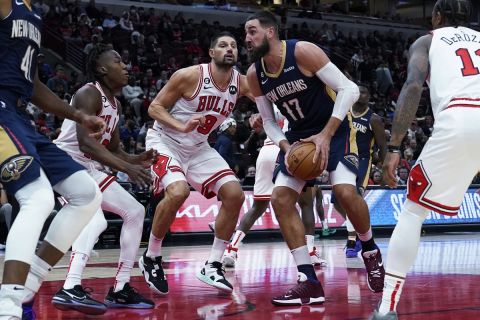 New Orleans Pelicans center Jonas Valanciunas (17) is defended by Chicago Bulls guard Ayo Dosunmu, left, and center Nikola Vucevic (9) during the second half of an NBA preseason basketball game in Chicago, Tuesday, Oct. 4, 2022. (AP Photo/Nam Y. Huh)