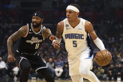 Orlando Magic forward Paolo Banchero (5) drives down the court past Los Angeles Clippers forward Marcus Morris Sr. (8) during the first half of an NBA basketball game Saturday, March 18, 2023, in Los Angeles. (AP Photo/Allison Dinner)